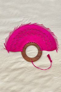 A bright pink woven hand fan 