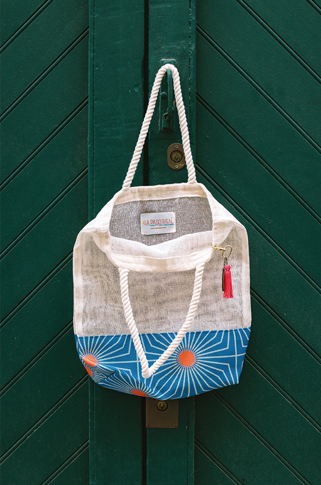 A welcome tote bag made of jute and a colorful print on the base.